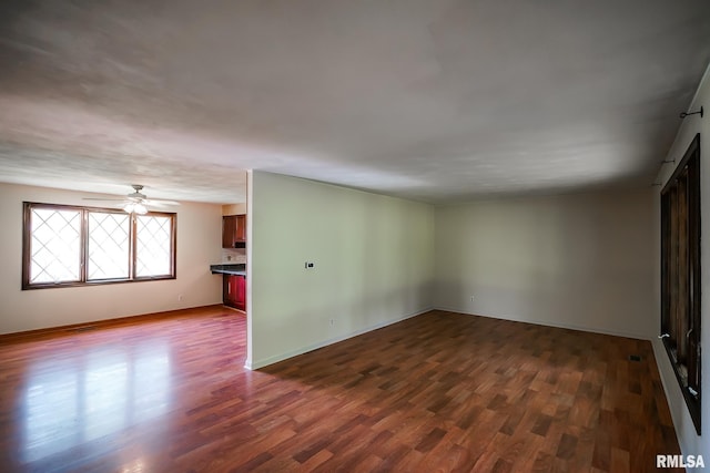 1529 W Richmar Rd, Peoria, IL 61615 - empty room with dark wood-style floors, a ceiling fan, and baseboards