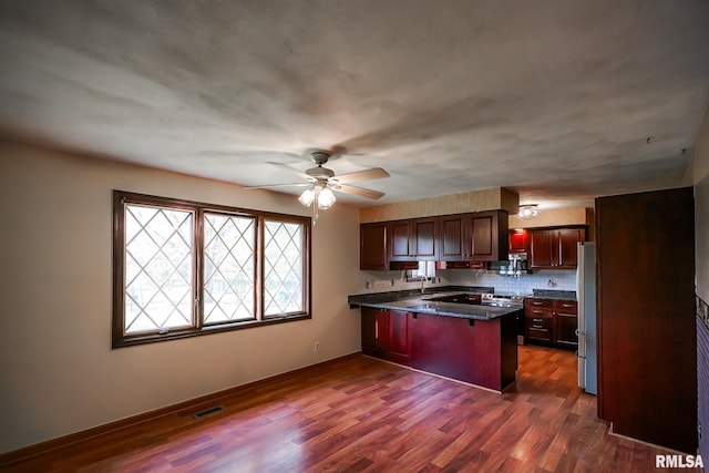 1529 W Richmar Rd, Peoria, IL 61615 - kitchen featuring appliances with stainless steel finishes, a peninsula, a ceiling fan, dark wood-type flooring, and a kitchen breakfast bar