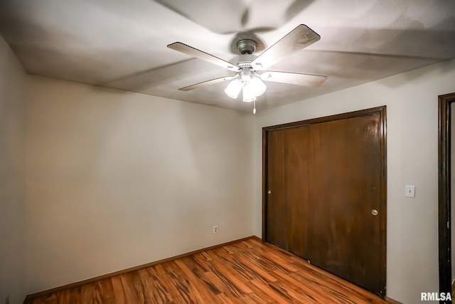 1529 W Richmar Rd, Peoria, IL 61615 - unfurnished bedroom featuring wood finished floors, a closet, baseboards, and ceiling fan