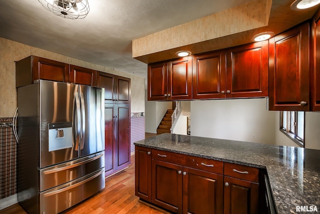 1529 W Richmar Rd, Peoria, IL 61615 - kitchen featuring stainless steel fridge with ice dispenser, light wood finished floors, dark brown cabinets, and dark stone countertops