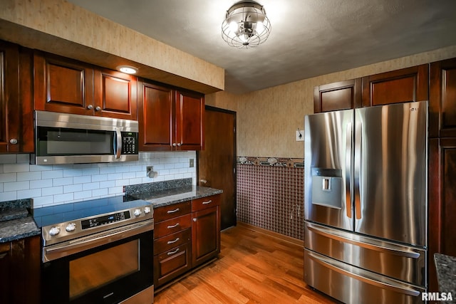 1529 W Richmar Rd, Peoria, IL 61615 - kitchen with stainless steel appliances, light wood finished floors, wallpapered walls, wainscoting, and dark brown cabinets