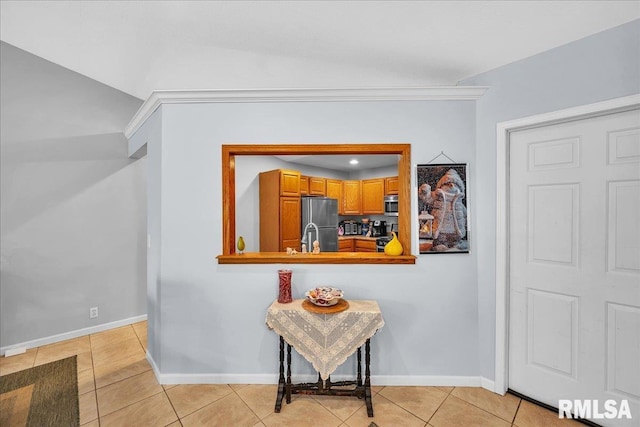 hall with light tile patterned floors, baseboards, and a sink