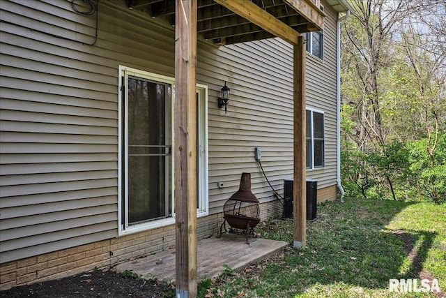 view of side of home featuring cooling unit and a patio area