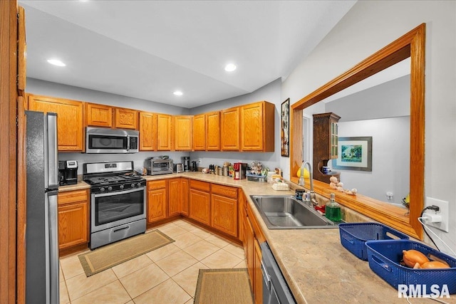 kitchen featuring stainless steel appliances, a sink, light tile patterned floors, light countertops, and recessed lighting