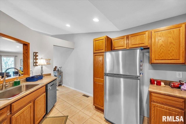 kitchen featuring dishwashing machine, a sink, freestanding refrigerator, light countertops, and recessed lighting
