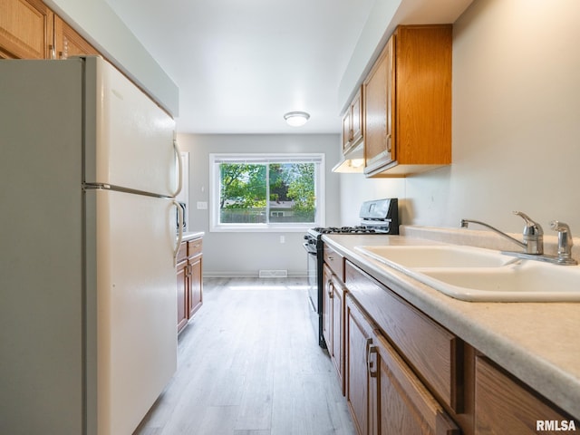 3509 S Dorothy Ct, Bartonville, IL 61607 - kitchen featuring freestanding refrigerator, black range with gas cooktop, a sink, light wood finished floors, and brown cabinetry