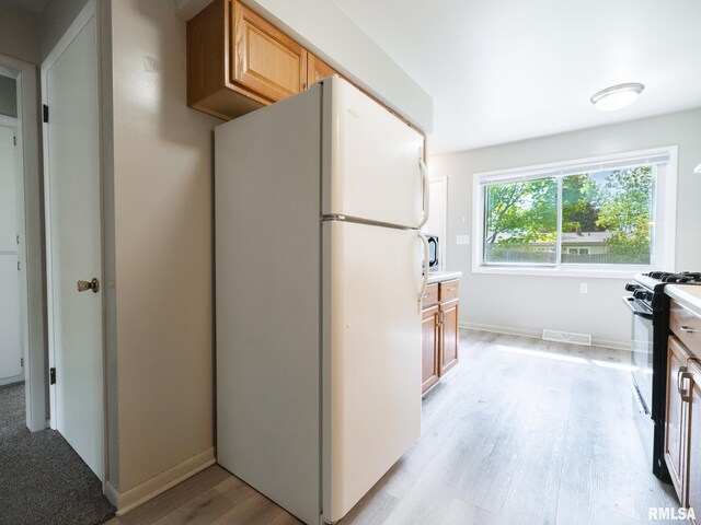 3509 S Dorothy Ct, Bartonville, IL 61607 - kitchen featuring freestanding refrigerator, black range with gas stovetop, light wood-style flooring, and baseboards