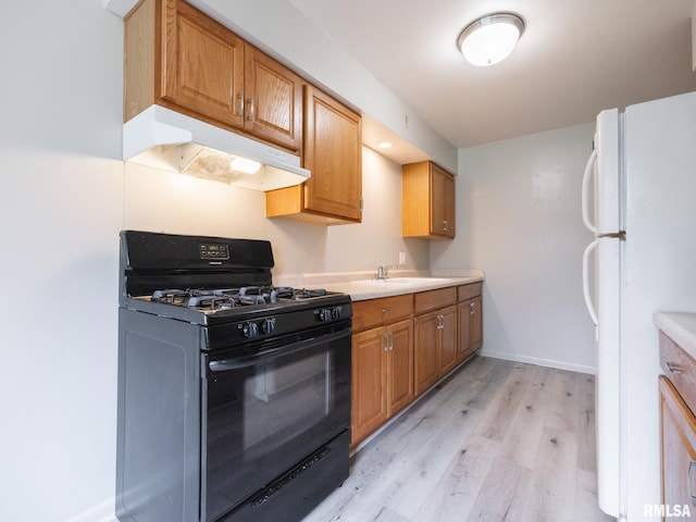 3509 S Dorothy Ct, Bartonville, IL 61607 - kitchen featuring black gas range, under cabinet range hood, freestanding refrigerator, light wood-style flooring, and light countertops