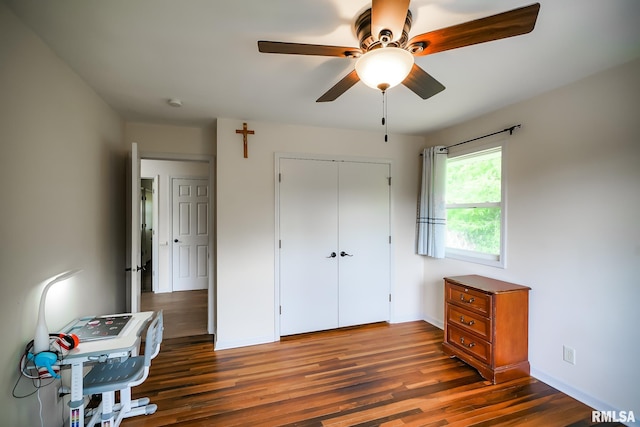 unfurnished bedroom featuring dark wood-style floors, a closet, a ceiling fan, and baseboards