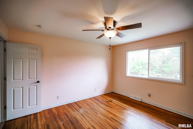 unfurnished room with ceiling fan, hardwood / wood-style flooring, and baseboards