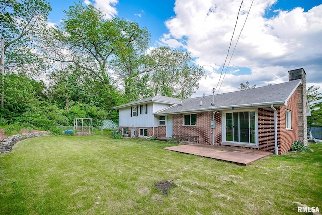 back of house with brick siding, a yard, a chimney, and roof with shingles