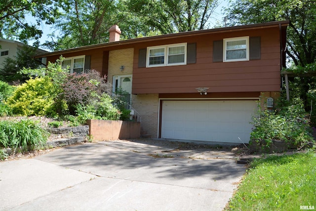 298 Jana Rd, Macomb, IL 61455 - raised ranch featuring an attached garage, brick siding, concrete driveway, and a chimney
