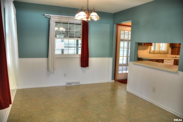 298 Jana Rd, Macomb, IL 61455 - unfurnished dining area with a chandelier, wainscoting, baseboards, and tile patterned floors