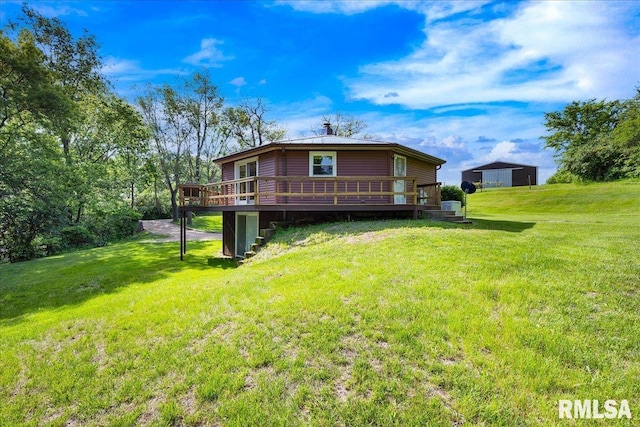 rear view of property featuring a wooden deck and a lawn