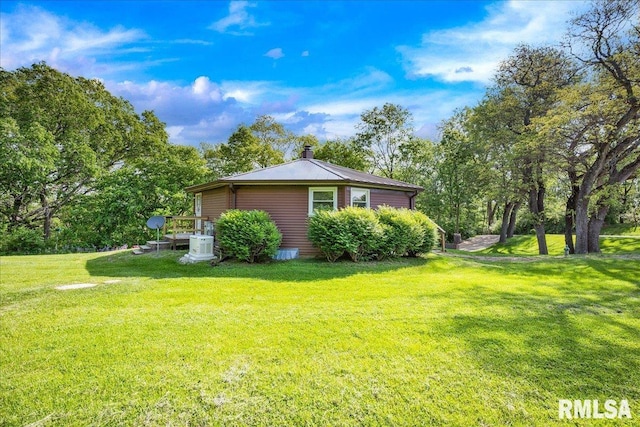 view of side of home with a lawn and a chimney