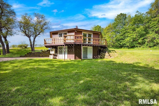 back of property featuring a wooden deck, a lawn, and a chimney