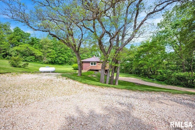 view of front of home with a front yard, metal roof, and a deck