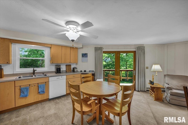 kitchen with white dishwasher, a sink, healthy amount of natural light, and ceiling fan