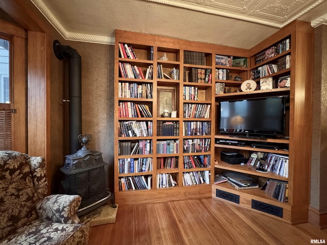 429 S Madison St, Macomb, IL 61455 - living area with wood finished floors, a wood stove, wall of books, and a textured wall