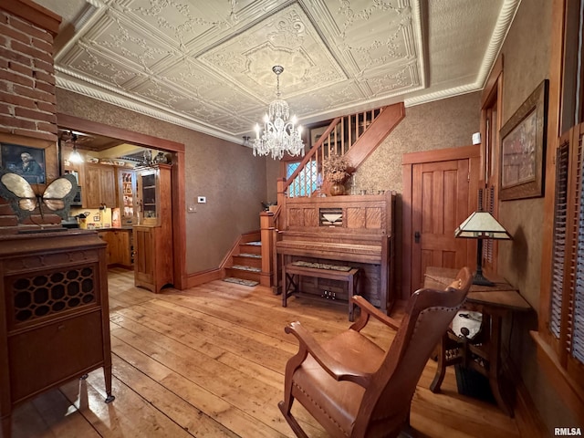 429 S Madison St, Macomb, IL 61455 - sitting room with an ornate ceiling, light wood-style floors, a chandelier, baseboards, and crown molding