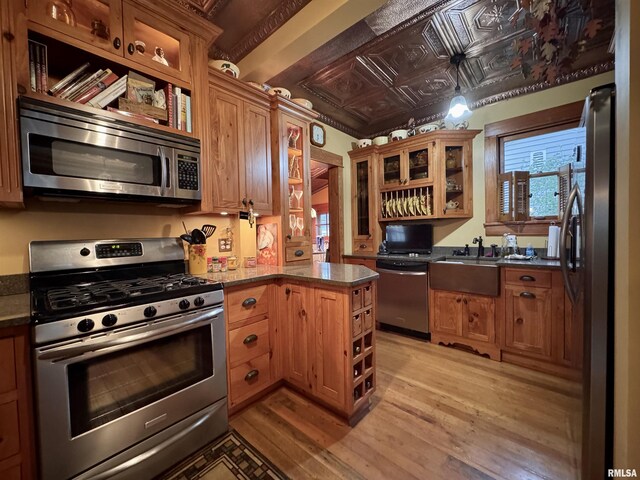 429 S Madison St, Macomb, IL 61455 - kitchen featuring appliances with stainless steel finishes, light wood-type flooring, a sink, and brown cabinets