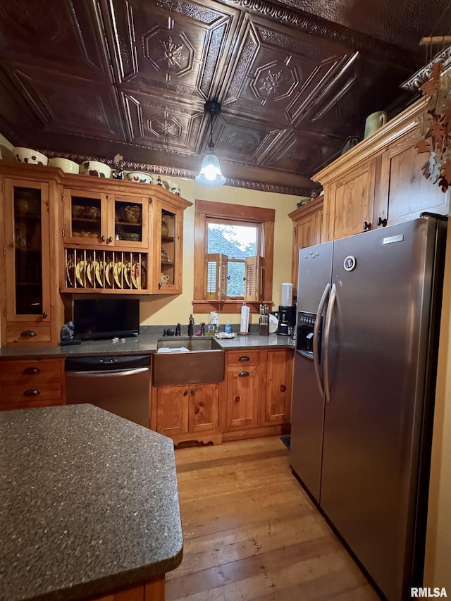 429 S Madison St, Macomb, IL 61455 - kitchen featuring stainless steel appliances, light wood finished floors, brown cabinets, an ornate ceiling, and glass insert cabinets