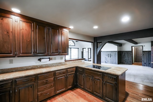 kitchen featuring black electric stovetop, light wood-style floors, a peninsula, dark brown cabinetry, and open floor plan