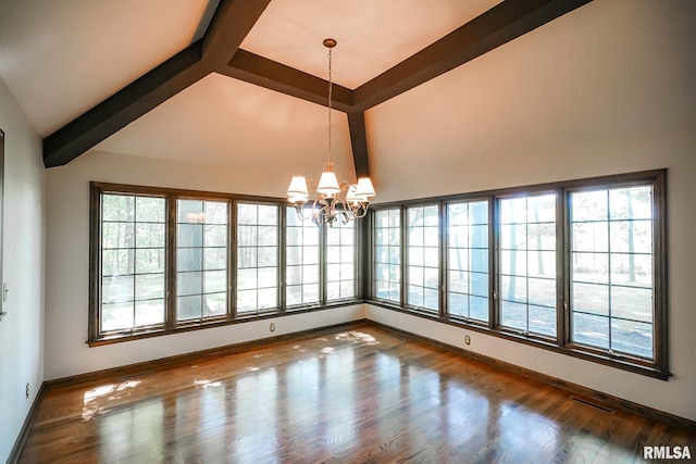 spare room with a chandelier, beamed ceiling, plenty of natural light, baseboards, and high vaulted ceiling
