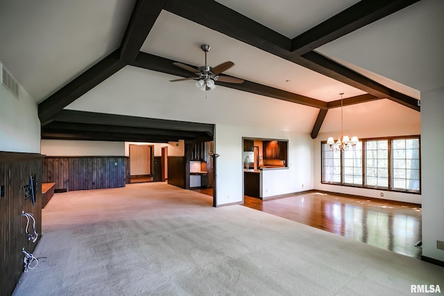 unfurnished living room with carpet flooring, beamed ceiling, a chandelier, a ceiling fan, and high vaulted ceiling