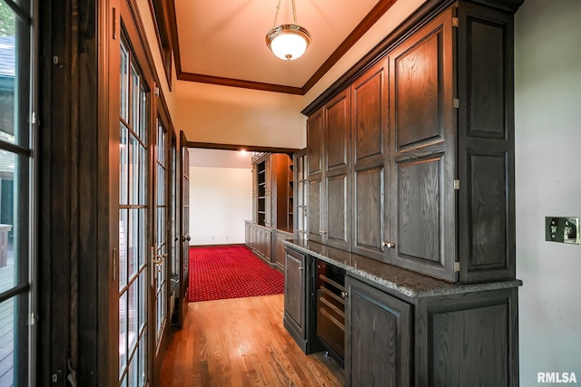 hall featuring light wood-style flooring, french doors, and ornamental molding