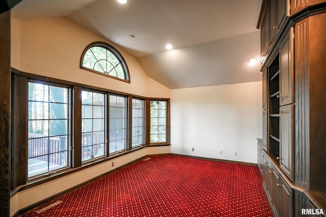 empty room featuring vaulted ceiling, dark carpet, baseboards, and recessed lighting