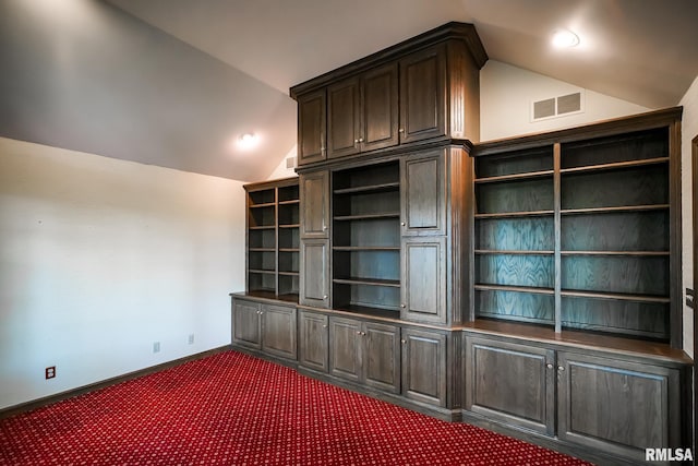 unfurnished office featuring lofted ceiling, dark carpet, and baseboards