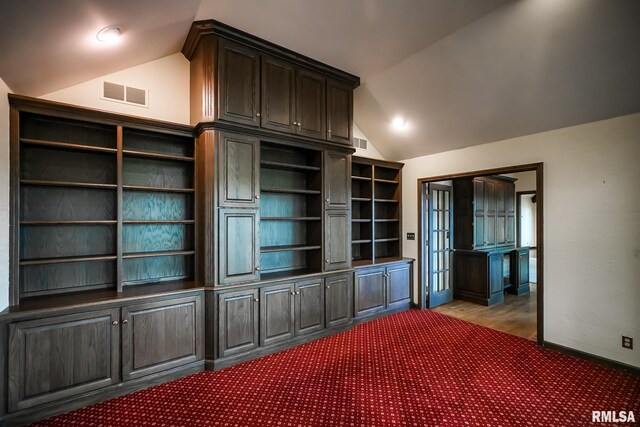 unfurnished bedroom featuring lofted ceiling and carpet