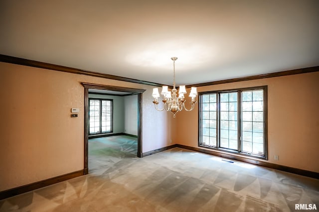 empty room featuring baseboards, a chandelier, crown molding, and light colored carpet