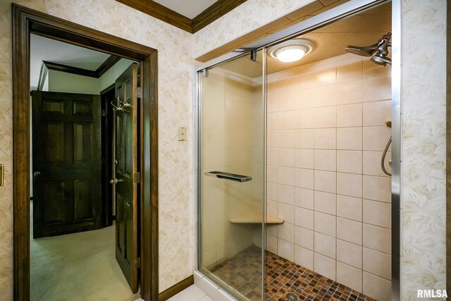 bathroom featuring crown molding, a shower stall, wallpapered walls, and baseboards