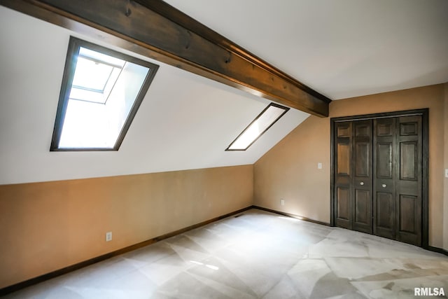 bonus room featuring a skylight, light colored carpet, and baseboards