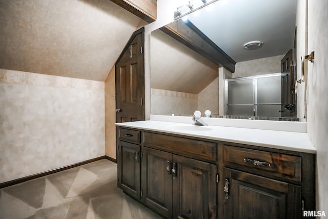 bathroom with vaulted ceiling, vanity, a shower, and baseboards