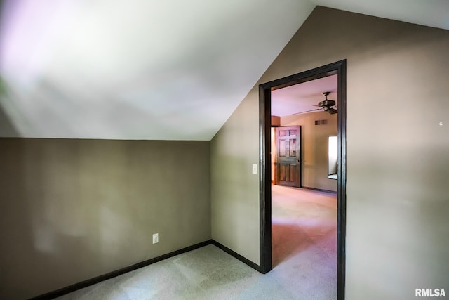 additional living space with lofted ceiling, light carpet, baseboards, and a ceiling fan