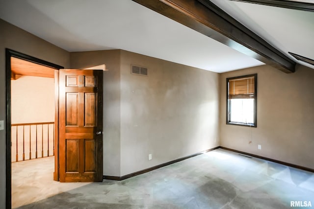 carpeted spare room featuring baseboards and beam ceiling