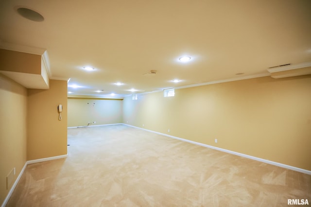 finished below grade area featuring crown molding, baseboards, recessed lighting, and light carpet