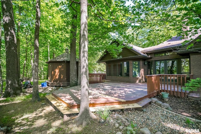wooden deck with a storage unit and an outdoor structure