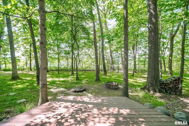 deck featuring an outdoor fire pit and a lawn