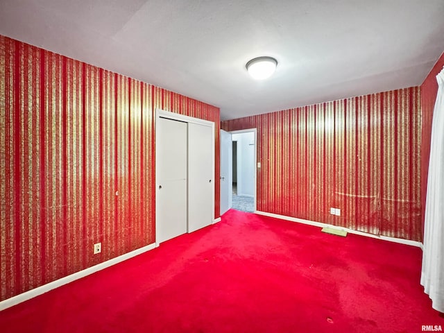 6006 N Big Hollow Rd, Peoria, IL 61615 - unfurnished bedroom featuring carpet floors, a closet, baseboards, and wallpapered walls