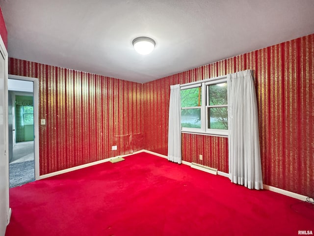 6006 N Big Hollow Rd, Peoria, IL 61615 - spare room featuring wallpapered walls, carpet, a baseboard heating unit, and baseboards