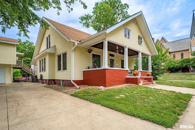 405 Washington St, Pekin, IL 61554 - view of front of home featuring covered porch, a front yard, concrete driveway, and an attached garage