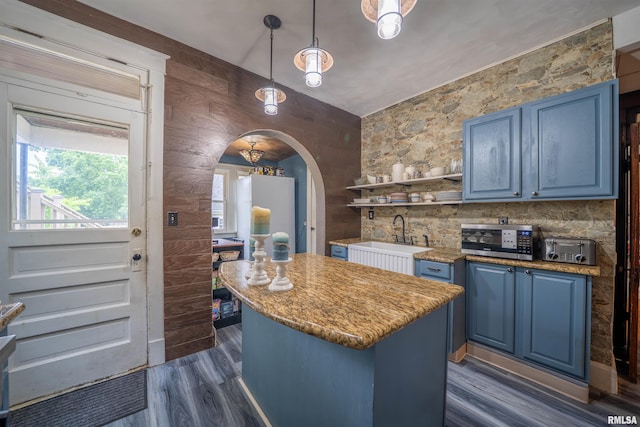405 Washington St, Pekin, IL 61554 - kitchen featuring blue cabinetry, a sink, stainless steel microwave, a kitchen island, and dark wood-style flooring