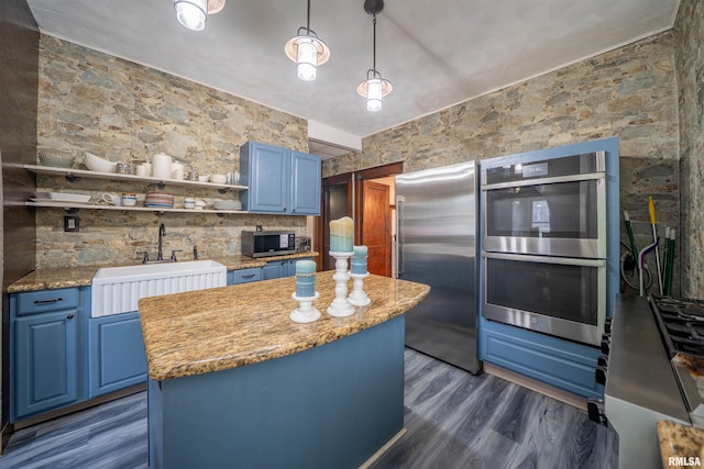 405 Washington St, Pekin, IL 61554 - kitchen featuring appliances with stainless steel finishes, blue cabinetry, a sink, and a center island