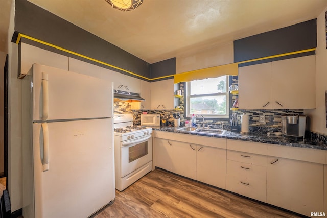 405 Washington St, Pekin, IL 61554 - kitchen featuring white appliances, a sink, under cabinet range hood, and dark countertops