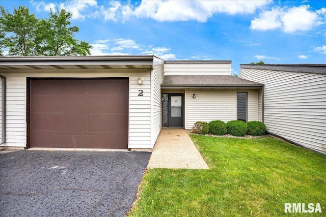 view of front of house with a front yard, a garage, and asphalt driveway