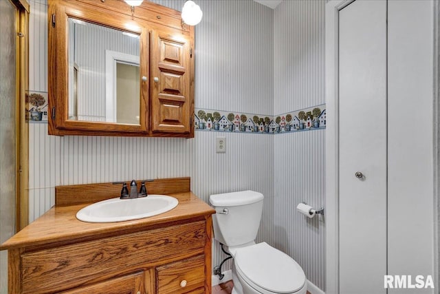 bathroom featuring wallpapered walls, toilet, and vanity